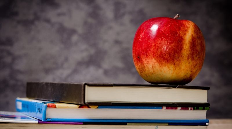 close up of apple on top of books