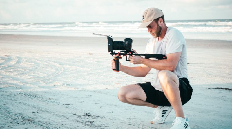man holding black dslr camera outdoors