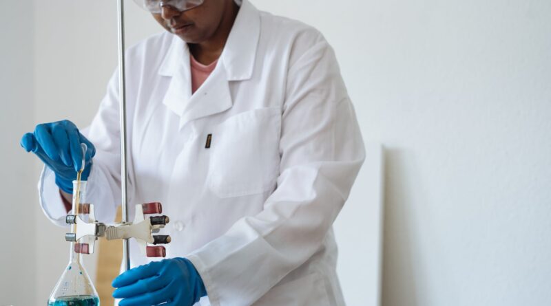 focused african american researcher conducting biochemical experiment in clinic