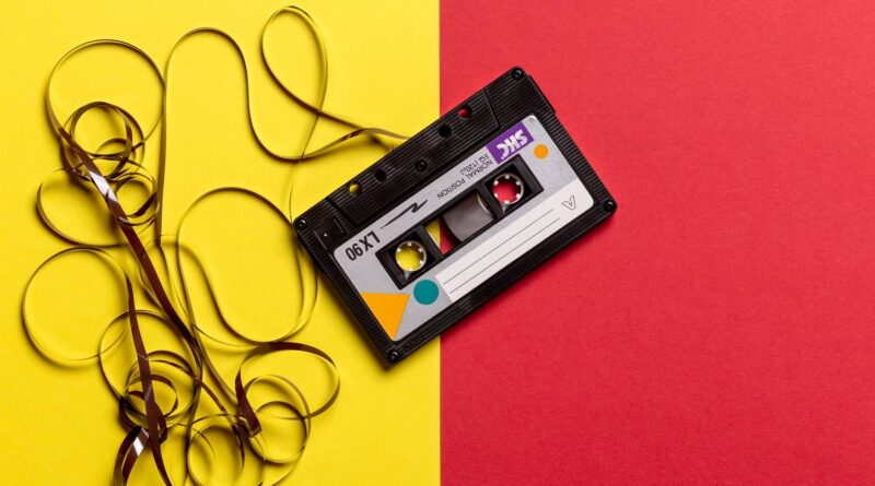 black cassette tape on top of red and yellow surface