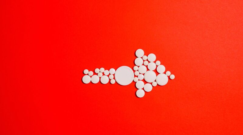 white round medication pill on red surface