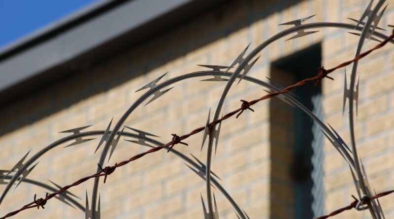 black metal wire fence near brown concrete building