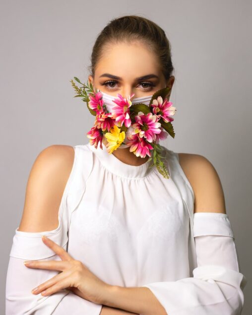 serious haughty woman in mask with flowers