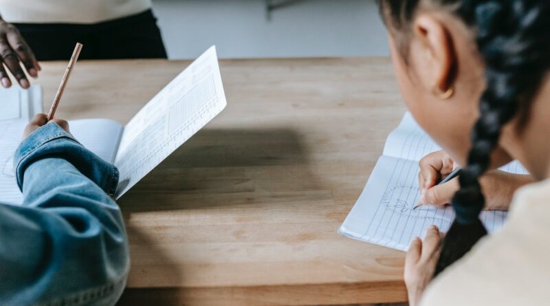 crop pupils with pencils and notepads in class