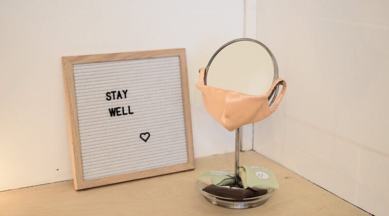 face mask placed on table mirror near framed image