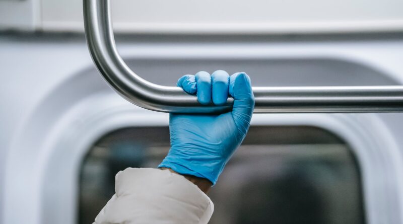 crop faceless black passenger grabbing overhead handle in train