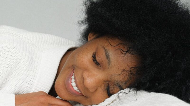 dreaming charming black woman leaning on table