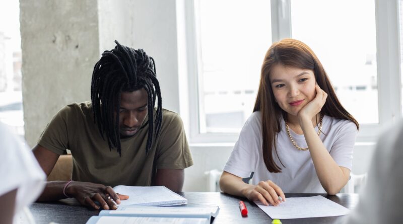 diverse students doing homework together in classroom