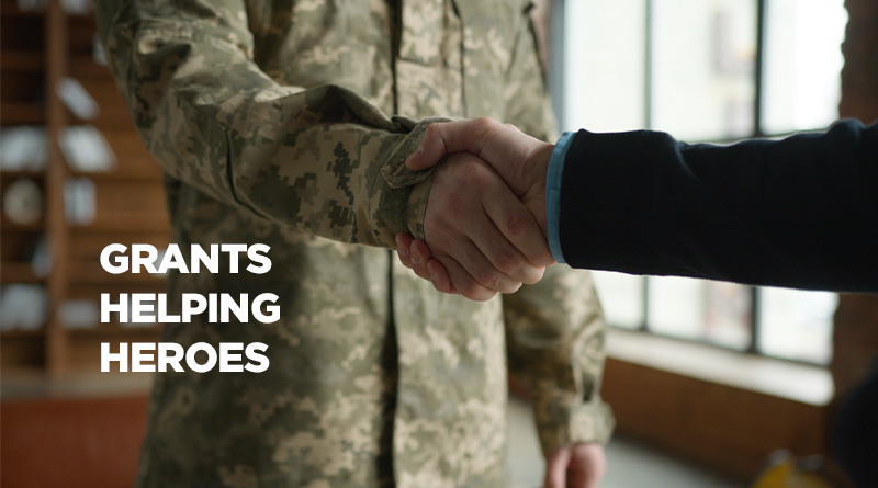 Military veteran shaking hands with the a nonprofit member with a caption reading, Grants Helping Heroes.