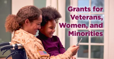 A smiling veteran in uniform, sitting in a wheelchair, looks at a smartphone with her young daughter, representing military families exploring unclaimed business grant money opportunities online.
