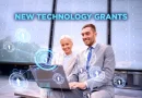 Two business professionals sitting outside and smiling while working on a laptop, with digital network graphics overlaying the image and the words 'New Technology Grants' displayed above them.