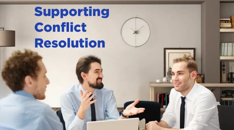 A group of three men in business attire sit around a table in a modern office, engaged in a friendly discussion. One man gestures with his hands while the others listen and smile. Laptops and a tablet are on the table. On the wall behind them is a clock and shelves with books. Blue text on the left reads “Supporting Conflict Resolution.”