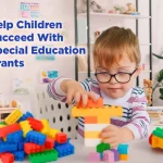 Young child with special needs playing with building blocks in a classroom, representing special education grant funding support.