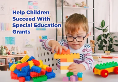 Young child with special needs playing with building blocks in a classroom, representing special education grant funding support.