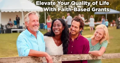 Four adults of different ages and backgrounds smile together at an outdoor community gathering, standing by a wooden fence with a tented event in the background, overlaid with the text “Elevate Your Quality of Life With Faith-Based Grants.”