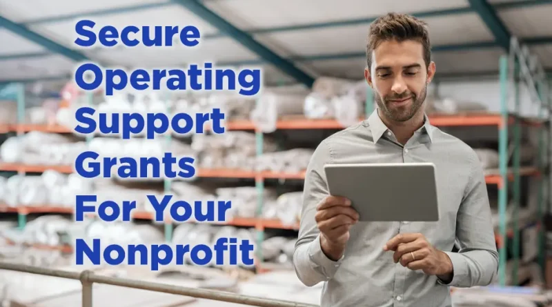 A professionally dressed man standing in a warehouse reviews a tablet while large blue text on the left reads, “Secure Operating Support Grants For Your Nonprofit.” Shelves stocked with supplies are visible in the background.