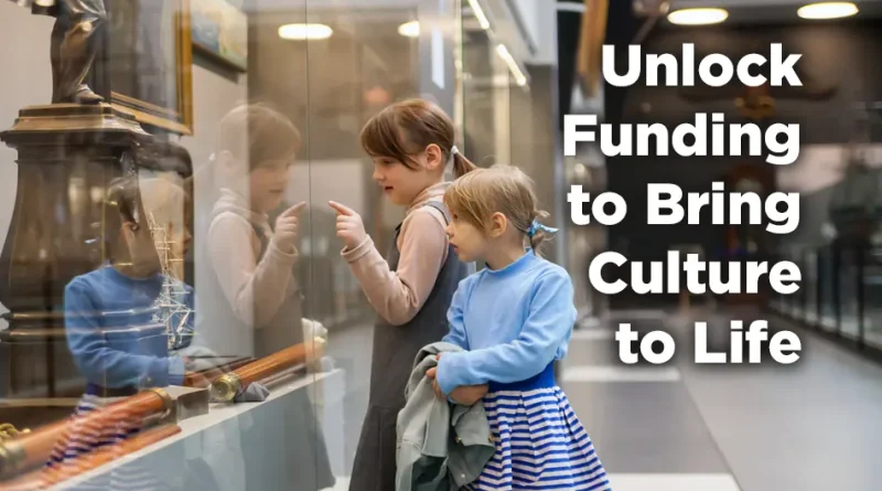 Two young girls stand in a museum gallery looking through a glass display case at historical artifacts, including a model ship, while the text reads “Unlock Funding to Bring Culture to Life” above the GrantWatch logo and the phrase “Time to Apply.”