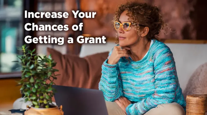 A woman sits on a comfortable couch. She is grinning and seems to exude confidence and surety. The caption reads: Increase Your Chances of Winning a Grant.