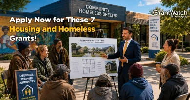 People gather outside a community homeless shelter as a presenter shares plans for affordable housing development. The image promotes seven housing and homeless grants available through GrantWatch to support shelters, housing access, and stronger communities.
