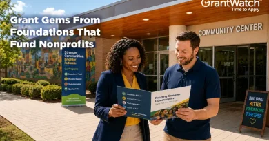 Two nonprofit professionals stand outside a community center reviewing a funding brochure. A colorful mural and community program signage are visible in the background. Overlay text reads, "Grant Gems From Foundations That Fund Nonprofits," with the GrantWatch logo displayed in the upper-right corner.