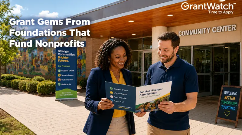 Two nonprofit professionals stand outside a community center reviewing a funding brochure. A colorful mural and community program signage are visible in the background. Overlay text reads, "Grant Gems From Foundations That Fund Nonprofits," with the GrantWatch logo displayed in the upper-right corner.