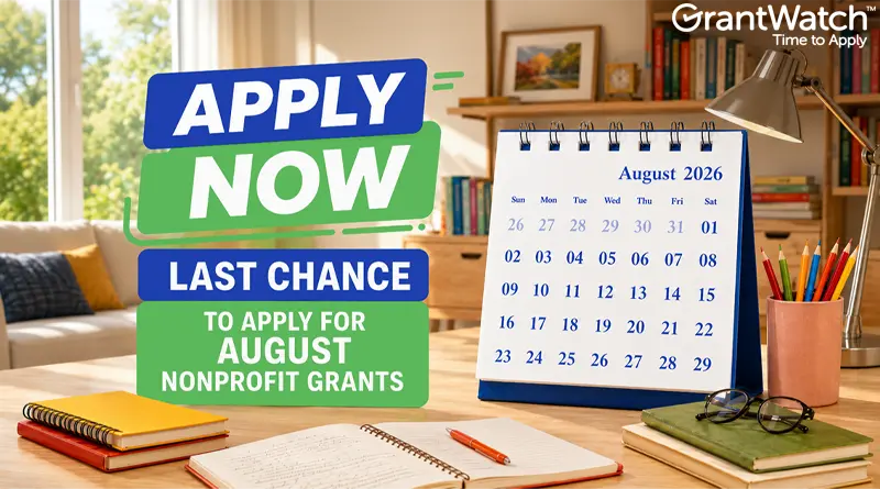 Graphic promoting nonprofit grant opportunities with the text "Apply Now: Last Chance to Apply for August Nonprofit Grants." A desktop calendar displays August 2026 beside notebooks, pens, glasses, and a desk lamp in a bright home office setting. The GrantWatch logo appears in the upper-right corner.