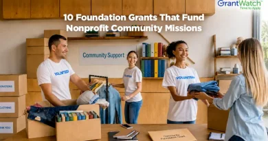 Alt text: Volunteers organize donated clothing, books, and supplies inside a nonprofit community support center. Text overlay reads, “10 Foundation Grants That Fund Nonprofit Community Missions,” with GrantWatch branding in the upper-right corner. Shelves, donation boxes, and community service materials highlight nonprofit outreach, volunteer engagement, and grant-funded support programs.
